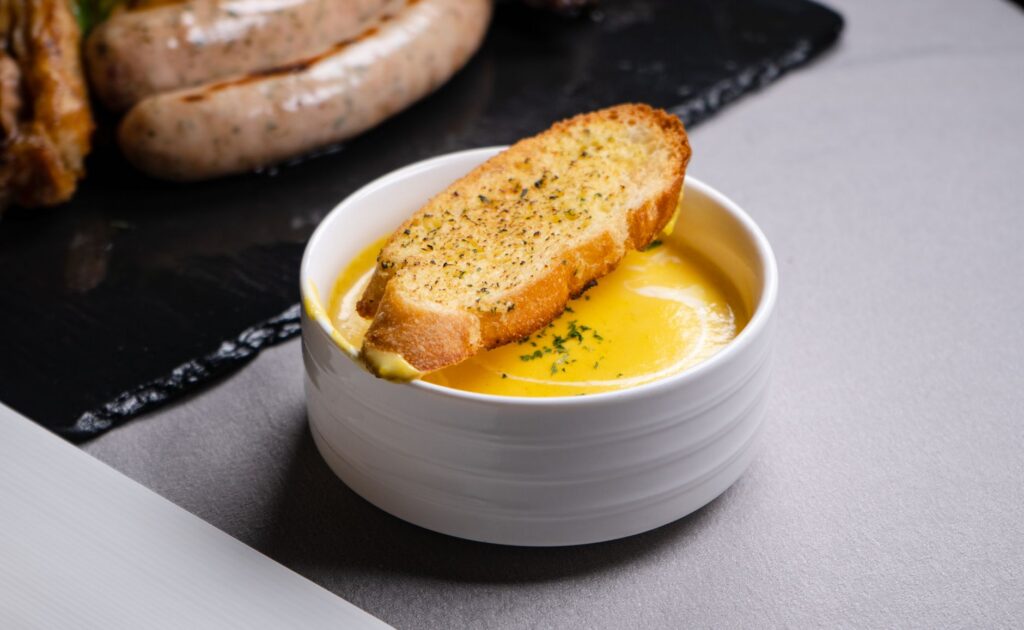 Delicious garlic bread served with a creamy cheese dip, perfect for a savory appetizer.